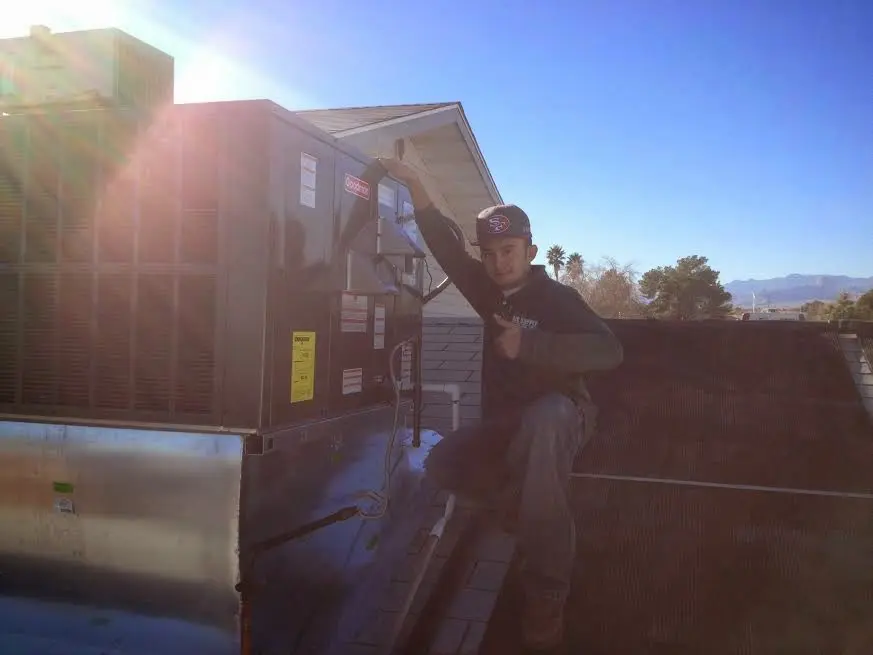 HVAC technician performing AC Tune-Up on a rooftop unit in Oberlin